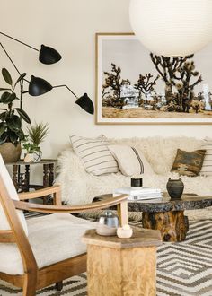 a living room filled with lots of furniture next to a painting on the wall over a coffee table