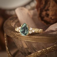 an antique ring with a green stone surrounded by pearls