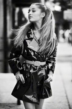 black and white photograph of a woman walking down the street with her hair blowing in the wind