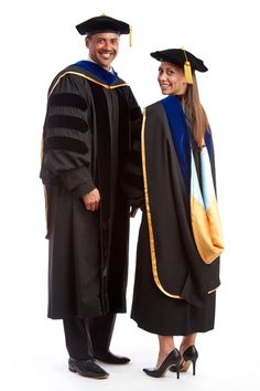 two people in graduation gowns posing for a photo