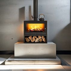 a wood burning stove sitting on top of a cement block