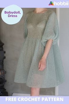 a woman in a green dress is standing next to a fireplace with the text babydoll dress free crochet pattern