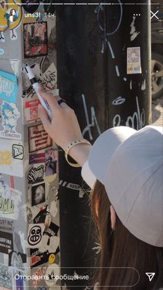 a person writing on a wall with stickers all over the walls and around them