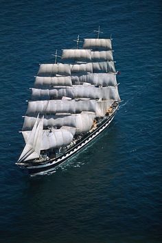 an old sailing ship in the ocean with sails down and white sails on it's side