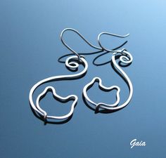 pair of silver earrings on blue background with name written in white letters and the shape of a cat's head