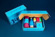 an open box with different types of crochet and yarn in it on a blue surface