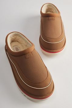 Updated classic Tasman slippers by UGG. Suede clogs with a plush inner lining and an indoor/outdoor treaded rubber sole. Features UGG Tasman Cali Wave clog Essential indoor/outdoor slipper Warm plush lining Rubber treaded outsole Content + Care Suede, polyester, rubber Spot clean Imported | UGG Tasman Cali Wave Slipper Clog in Chestnut/Birch, Men's at Urban Outfitters Brown Slip-on Indoor Clogs, Brown Slip-on Clogs For Indoor Use, Brown Indoor Clogs With Rubber Sole, Tasman Slippers, Indoor Outdoor Slippers, Cozy Boots, Ugg Tasman, Suede Clogs, Men's Shoes Accessories