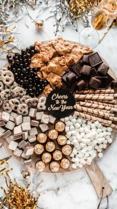 a platter filled with different types of chocolates and candies next to confetti