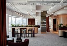 an office with high ceilings and lots of seating around the bar area is pictured in this image