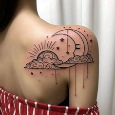 the back of a woman's shoulder with stars and clouds on it