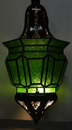 a green stained glass light hanging from the ceiling