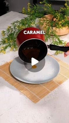 someone is pouring caramel into a bowl on a plate with flowers in the background