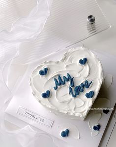 a heart shaped cake on top of a white card with blue hearts and the words my love written on it