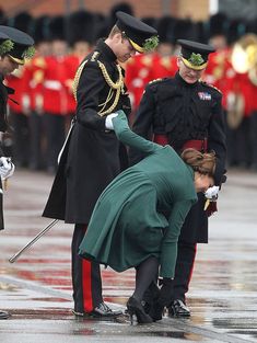 the queen is bowing down in front of soldiers