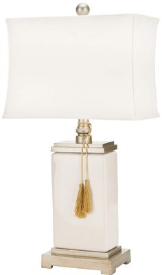 a white lamp with a gold tassel on it