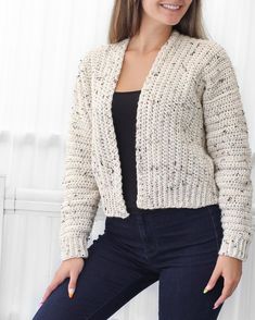 a woman is posing for the camera wearing a cardigan