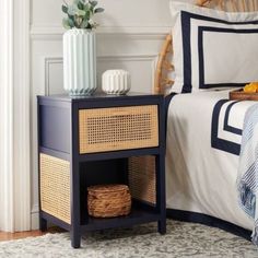 a bed room with a neatly made bed and a basket on the nightstand next to it