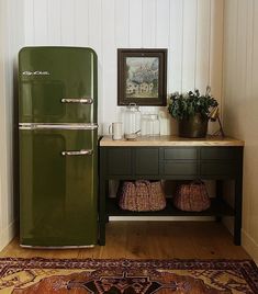 a green refrigerator sitting on top of a wooden floor next to a table and rug