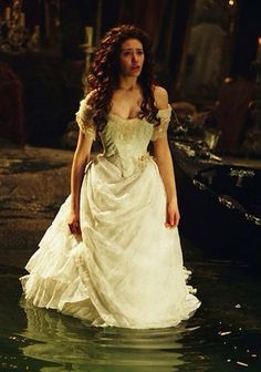 a woman in a white dress standing in water