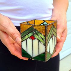 a person holding a stained glass object in their hands