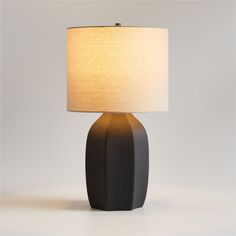 a black table lamp with a white shade on it