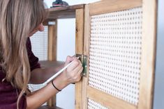 a woman is working on a piece of furniture