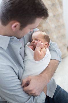 a man holding a baby in his arms