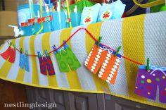 colorful birthday party decorations hanging on the kitchen counter with paper tags and streamers in front of them