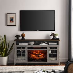 an entertainment center with a fireplace in the middle and a flat screen tv above it