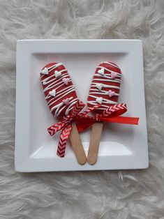 two red and white candy pops on a plate