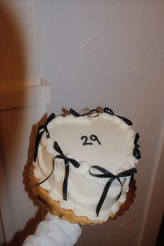 a person holding up a cake with the number twenty on it