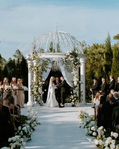 a bride and groom standing at the end of their wedding ceremony in front of an outdoor gazebo