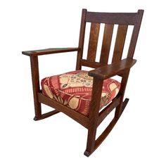 a wooden rocking chair with a cushion on it's seat and armrests