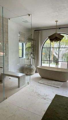 a bathroom with a tub, sink and large window