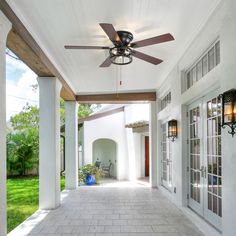 an outdoor patio with ceiling fans and white walls