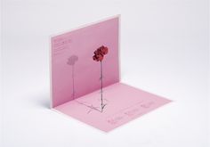 a pink card with a single flower on the front and back of it's cover