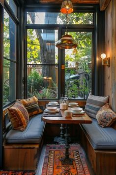 a table with two plates and cups on it in front of a large glass window