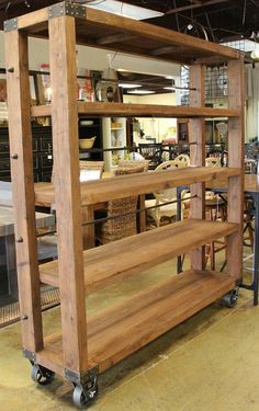 a large wooden shelf sitting inside of a kitchen next to a stove top oven on wheels