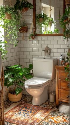 a white toilet sitting in a bathroom next to a mirror and potted plants on the wall