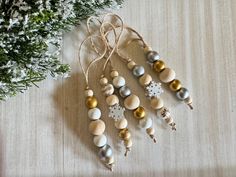 some ornaments are hanging on a table next to a tree with snowflakes and pine cones