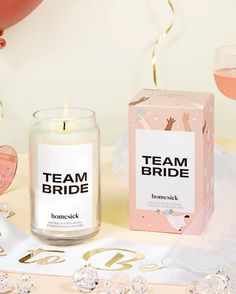 a candle that is next to a box and some confetti on a table