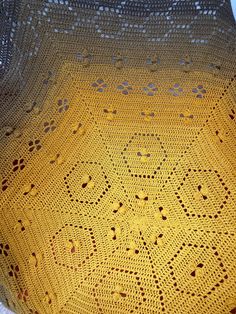 a yellow crocheted blanket sitting on top of a table