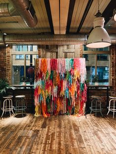 a room with wooden floors and walls decorated with colorful streamers hanging from the ceiling