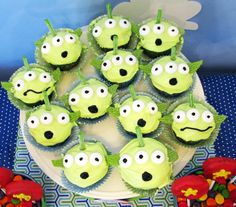 cupcakes with green frosting and eyes are arranged in the shape of plants