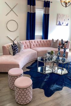 a living room with pink couches and blue rugs on the wooden flooring