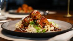 a white plate topped with meat and rice covered in sauce