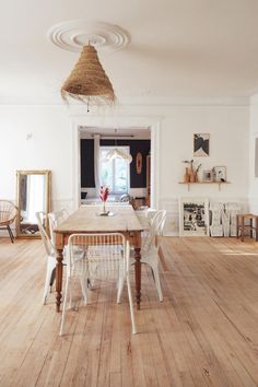 a dining table and chairs in a room with white walls, wood floors and wooden flooring