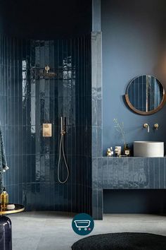 a bathroom with blue walls and tile flooring is pictured in this image, there are two mirrors on the wall next to the shower