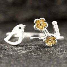 two yellow flowers are sitting on top of each other in silver ring rings with gold centers