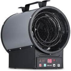 an electric heater sitting on top of a white table next to a black clock